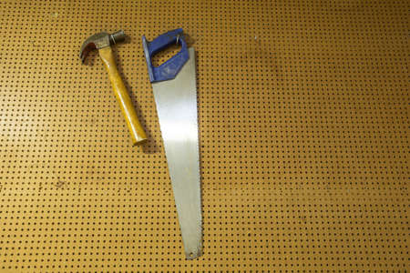 Hammer and saw on tool rack in the garage