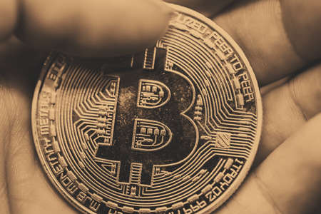 Golden Bitcoin in a man hand, Digitall symbol of a new virtual currencyの写真素材