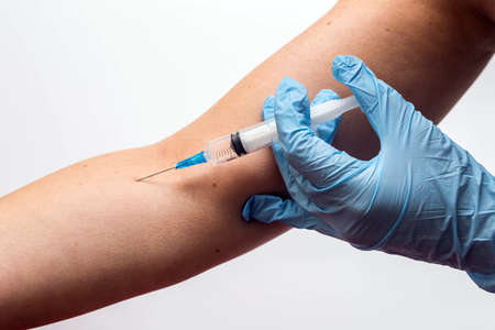 Doctor or nurse giving vaccine injection in arm to a patiend isolated on whiteの写真素材