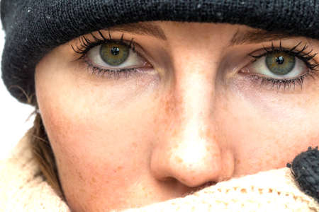 Portrait of woman wrapped in winter had and scarf, winter woolen wearing looking coldの写真素材