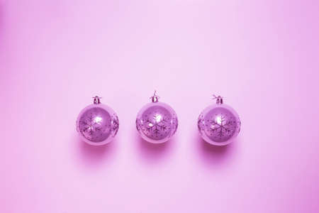 Pink Christmas ball baubles isolated on pink background, modern retro christmas ornamentの写真素材