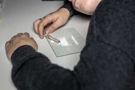 Young woman snorting drugs, cocaine or speed or other drugs abuse, addiction