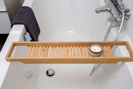 Closeup of new clean white modern bathtub with towel and candle, modern interiorの写真素材