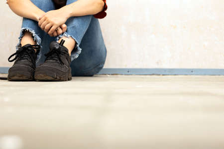 Young woman sitting on the floor in a new home, needs renovation, space for textの写真素材