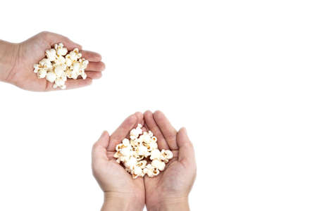 Hand holding popcorn isolated on the white background, space for textの写真素材