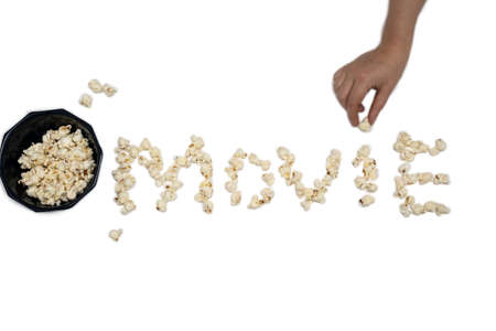 popcorn isolated on white background forming the word Movie with hand holding popcornの写真素材