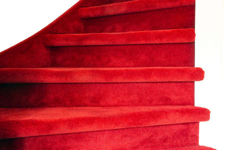Red carpet on white wooden stairs in a home, close-up luxury modern interiorの写真素材