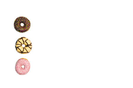 various colored delicious donuts on white background, space for text Fastfood