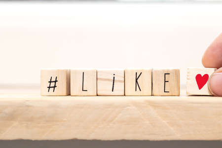 Wooden cubes with hasthag and the word like, social media concept close-upの写真素材