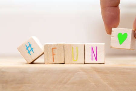 Wooden cubes with hashtag and the word Fun in various colors, social media concept background close-upの写真素材