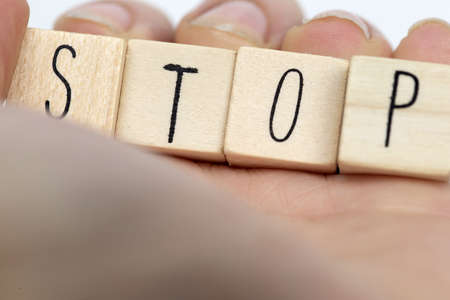 Human hand with wooden cubes and a hashtag with the word stop, social media concept backgroundの写真素材