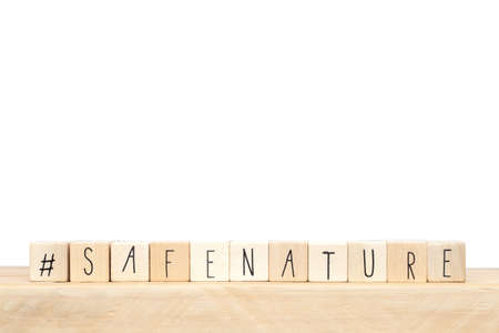 Wooden cubes with a hashtag and the words Safe Nature, social media concept, near white background