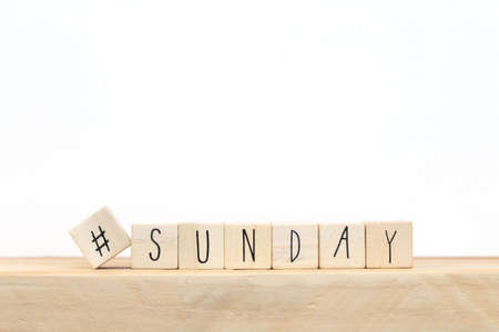 Wooden cubes with a hashtag and the word Sunday, social media concept near white backgroundの写真素材