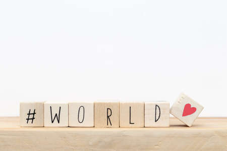 Wooden cubes with a hashtag and the word World, social media concept near white background close-upの写真素材