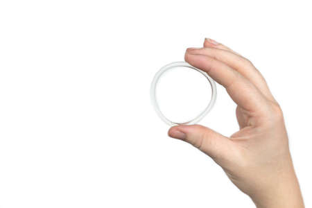 Birth control ring in a womans hand isolated on white background, vaginal ring for contraceptive use