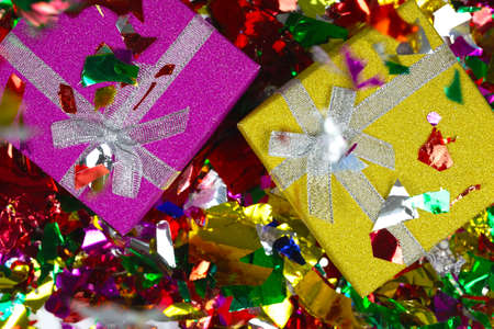 Colorful sparkling birthday or other concept presents in purple and yellow box with confetti top...
