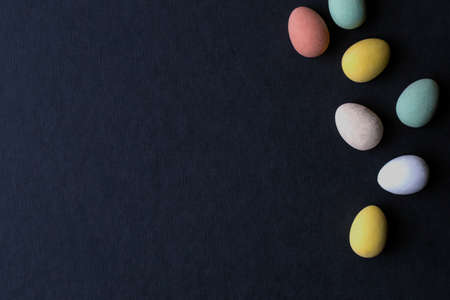 painted Easter Eggs various colors on black background, top view modern design space for text, April...