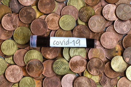 Coronavirus blood sample lying on Euro coins, Covid-19 virus test, business conceptの写真素材