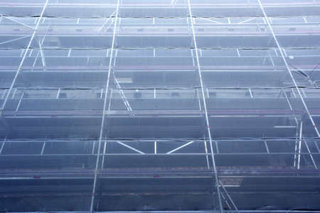 High building in Scaffolding against blue sky, construction works at building site, restoration new...