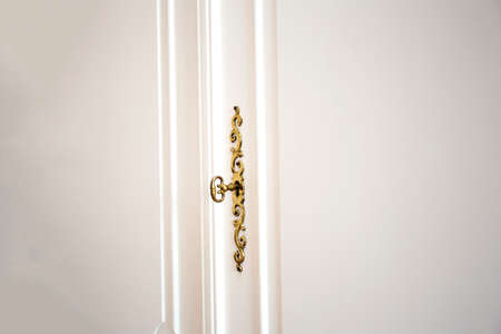 White cupboard doors with Golden key in keyhole, luxury antique design close-up wooden vintage doors beautyの写真素材