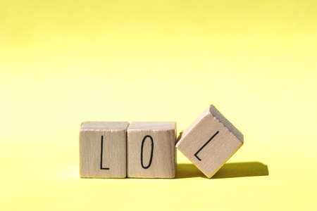 alphabet wood blocks forming the word lol on retro Yellow background, modern designの写真素材
