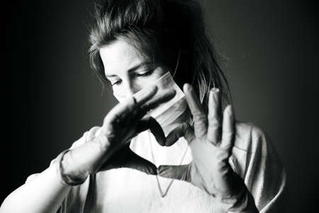 Young woman wearing protection mask against Covid-19, Coronavirus looking depressed and isolated, black and white portrait virus conceptの写真素材
