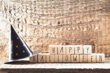 Words Happy Halloween on wooden cubes with group of scary ghost on wooden background, autumn mood...