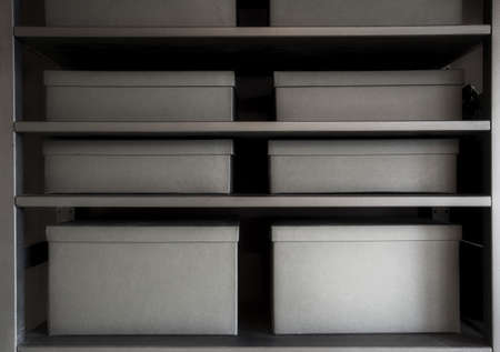 Shelves with cardboard storage boxes in black for office or home close upの写真素材