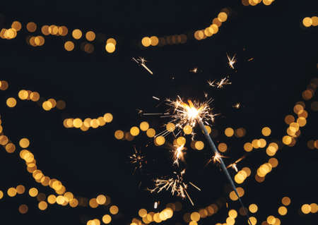 Burning Sparkler with Festive bokeh background for New Year and Christmas concept, space for text