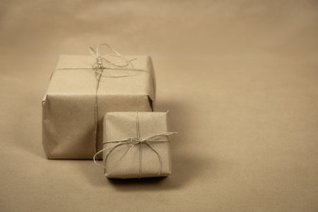 two gift package wrapped with plain brown paper and rope and brown paper background texture, retro gift box. present conceptの写真素材