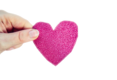 Female hand holding sparkling pink heart isolated on white background for Valentines Day or romantic, Health conceptの写真素材