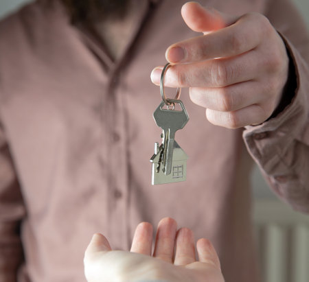 Estate agent giving house keys to client for new home, contract real estate for mortgage approved, focus on keys, business, financial, Estate conceptの写真素材