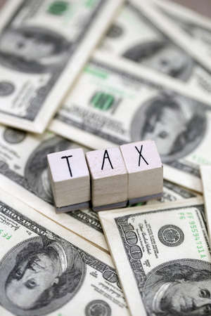 Tax text with hundred dollar bills background, business, financial and tax time conceptの写真素材