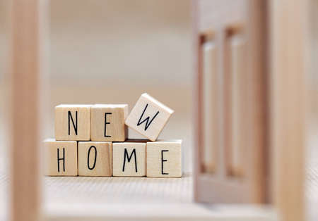 New Home text written with wooden cubes background with symbol of cozy little house with blurred background design, purchase real estate,mortgage loan, property owner concept backgroundの写真素材