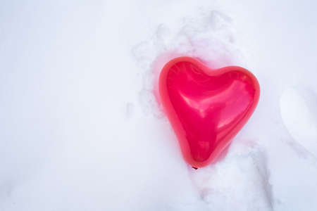 Beautiful red heart balloon for Valentines Day in the fresh white snow background, copy space, Valentine,winter,love conceptの写真素材