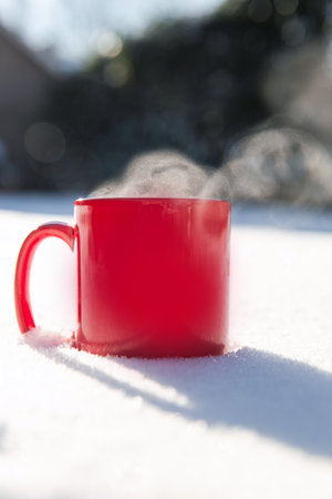 Steaming cup of hot coffee,tea or chocolatemilk in the cold fresh white snow, Winter,cozy,drink,snowy day concept background in natureの写真素材