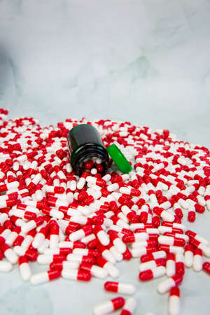 Bottle with red and white capsule on white background, Vitamin, drugs or pharmaceutical medication...