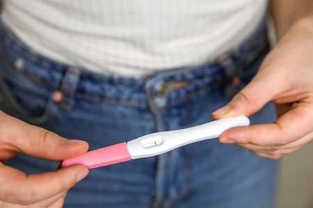 Young woman holding negative pregnancy test,home pregnancy test showing negative result close upの写真素材