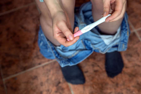 Young woman checking results of a pregnancy test in bathroom close-up, new life, family, mother, baby concept modern designの写真素材