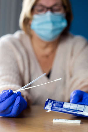 Senior woman studying and taking the self test for , home test kit for coronavirus close-up