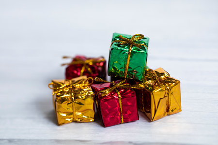 Pile of colored shiny gift boxes with copy space on white wood background,modern retro Christmas...