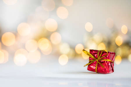 christmas present red and silver baubles against bokeh lights gold shiny glitter background with copy spaceの写真素材