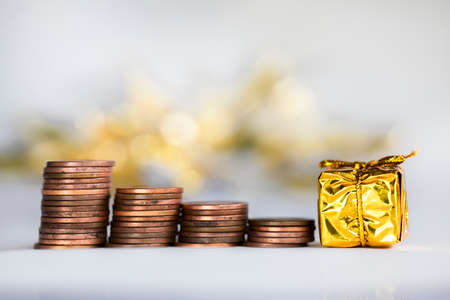 Coin climbing stairs with Christmas Holiday present, sparkling and shiny background, Finance,saving concept stacks of coinsの写真素材