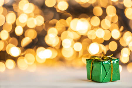 christmas present red and silver baubles against bokeh lights gold shiny glitter background with copy spaceの写真素材