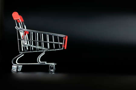Shopping cart empty on black background with copy space, shopping and black Friday concept.の写真素材