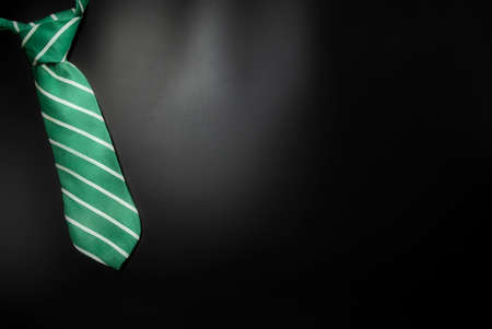 Necktie on dark shadow black background with copy space, International Mens Day and Fathers Day concept.の写真素材