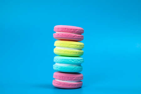 Pile of fresh baked colorful French macaroons on blue background , copy space banner. dessert,cookie,cake conceptの写真素材