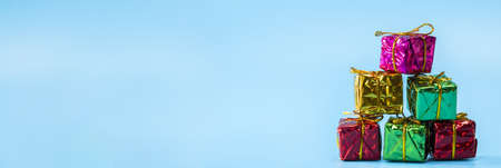 Christmas gift boxes on blue background, pile of Christmas presents modern design, background Banner with copy space. Holiday,gift,banner conceptの写真素材