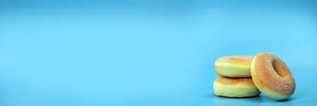 Long horizontal banner with three simple donuts on blue background. Colorful donuts with copy space in center.sugar fastfood conceptの写真素材