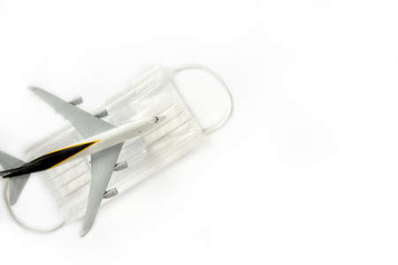 Travel and health concept during covid-19 pandemic. passenger airplane and white masks isolated on white background, travel,coronavirus concept with copy spaceの写真素材